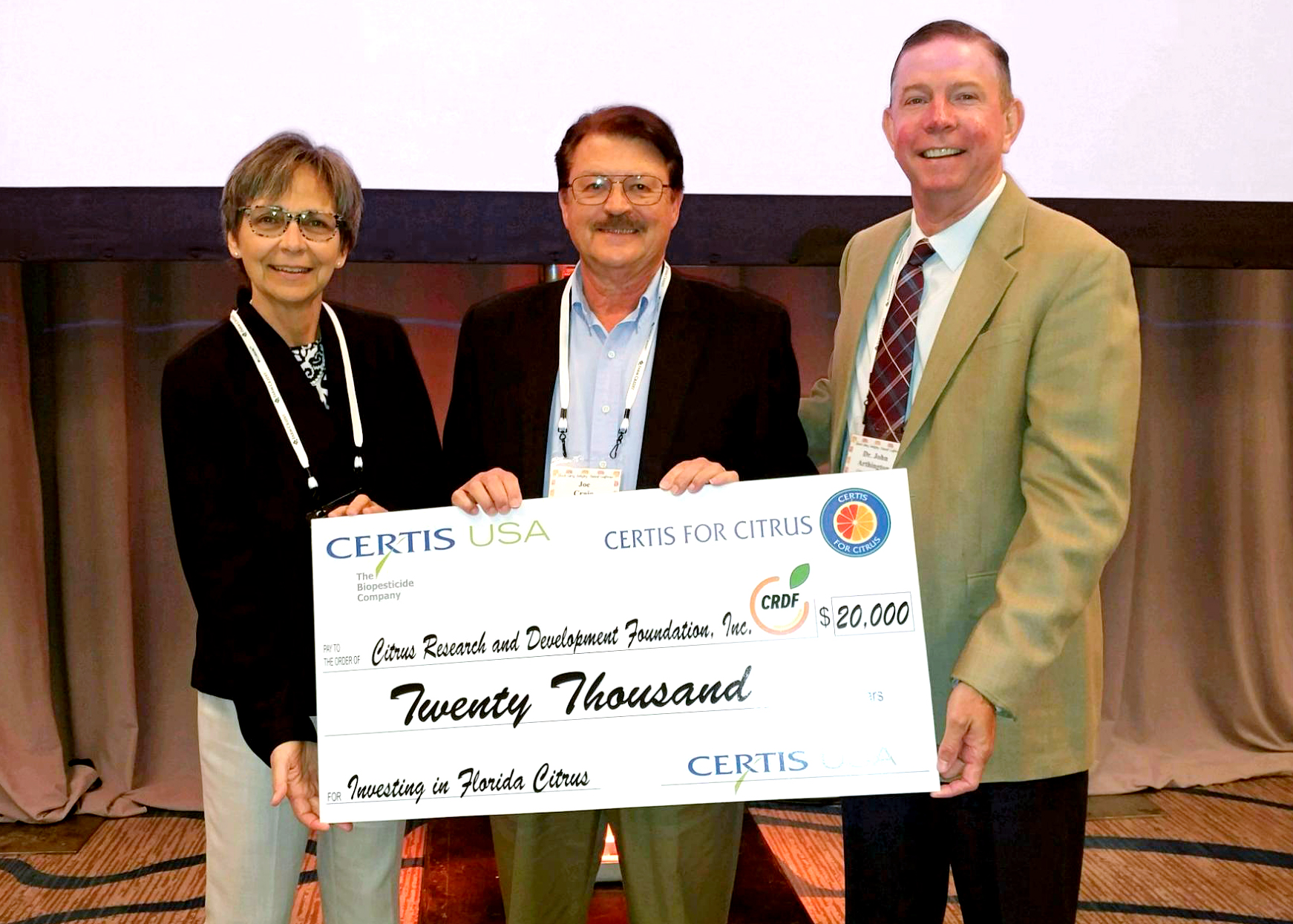 Three people accepting a donation check. 